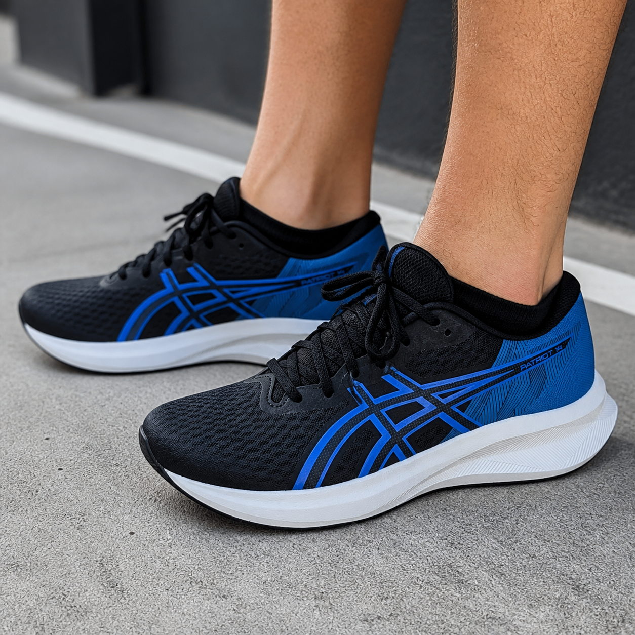נעלי ריצה לגברים ASICS Patriot 14 שחור/כחול על הרגל
